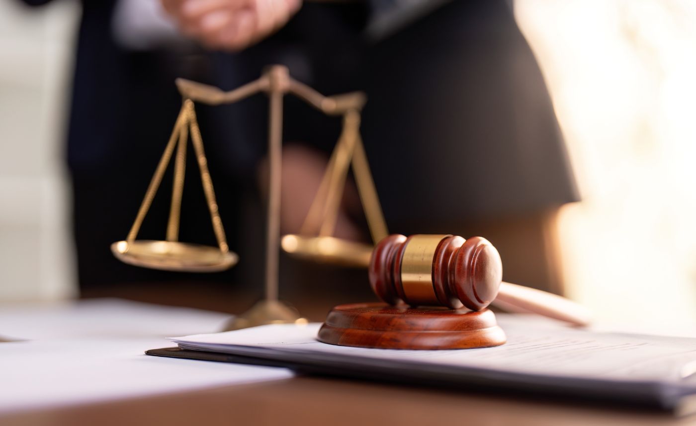 Mazo judicial y balanza dorada sobre documentos legales en una oficina