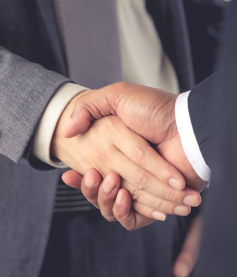 Apretón de manos entre dos personas con traje formal